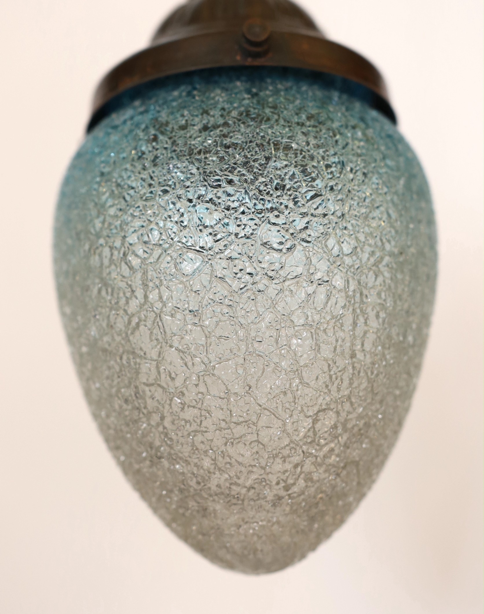 A 1920's English bronzed metal light pendant with blue tinted frosted glass shade, height 22cm